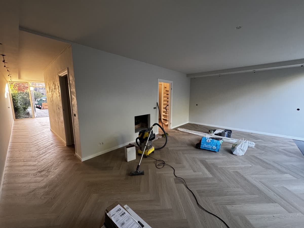 De nieuwe visgraatvloer ligt in de woonkamer en de gang, met de plinten erop