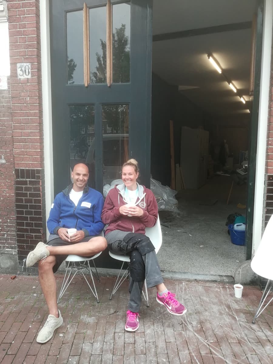 Jidde en Sharon drinken koffie voor de deur van een winkelpand in Haarlem dat ze samen verbouwen